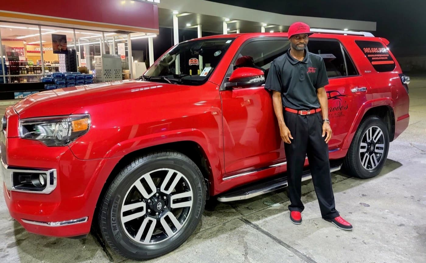 Jerode standing beside a red Joy Ride SUV