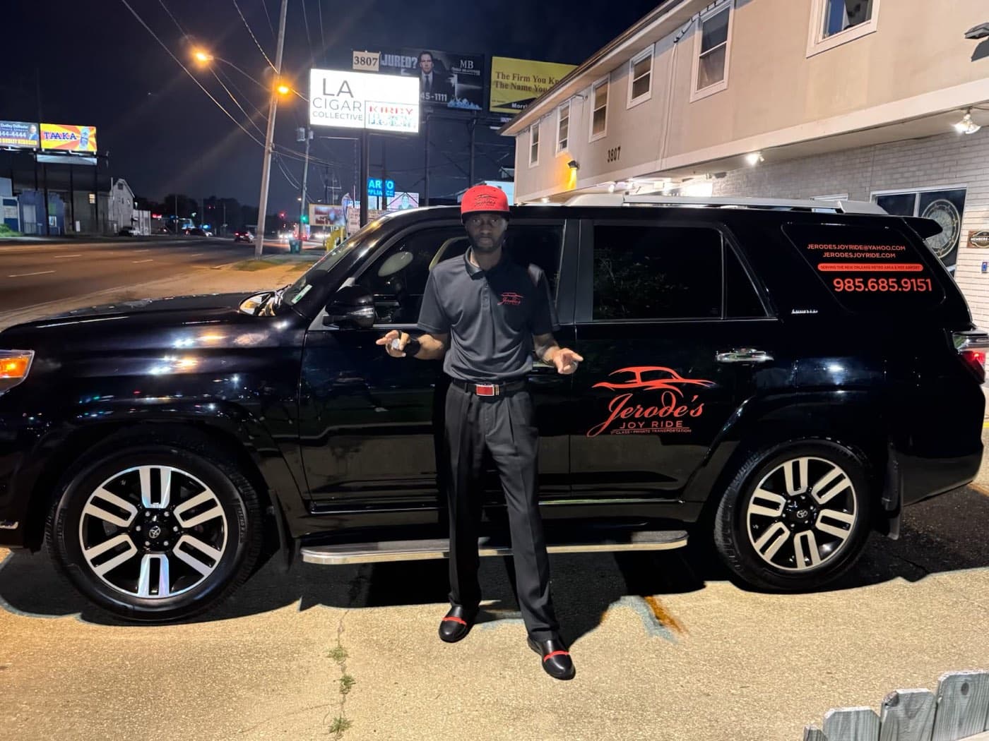 Jerode standing beside the black Joy Ride SUV at night