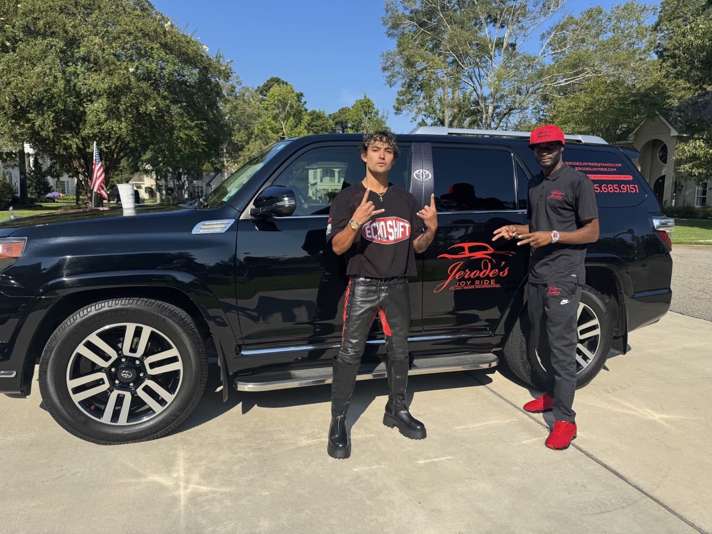Jerode and a rider standing beside the black SUV