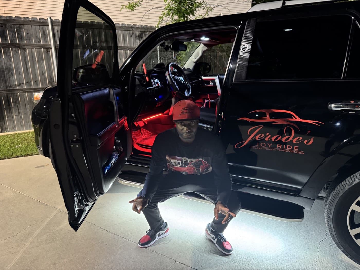 Jerode beside the SUV with red cabin and ground lighting
