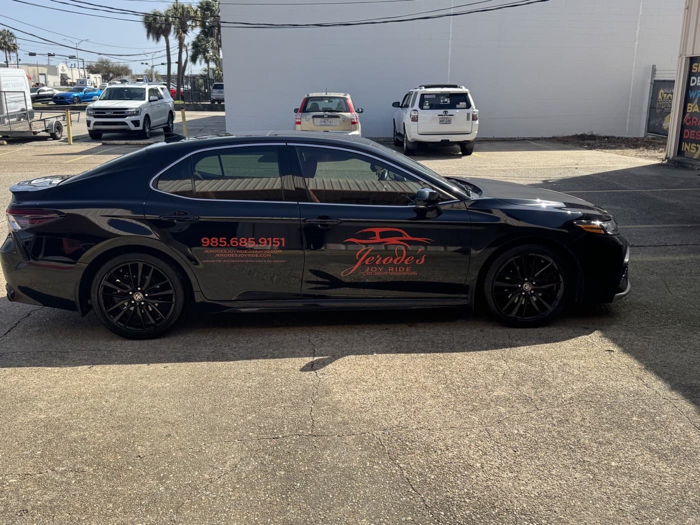 Black branded Joy Ride sedan viewed from the passenger side