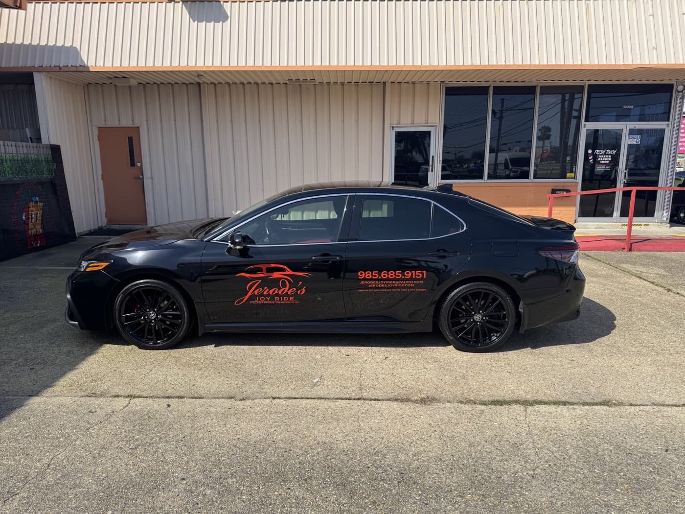 Black branded Joy Ride sedan viewed from the driver side