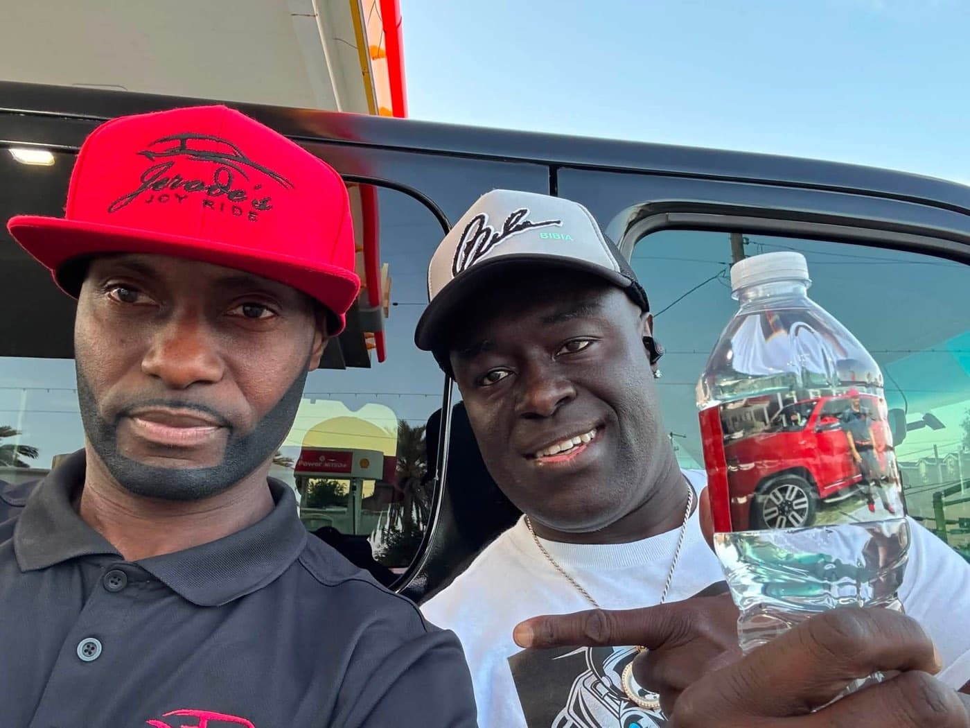 Jerode posing with a smiling rider beside the passenger van
